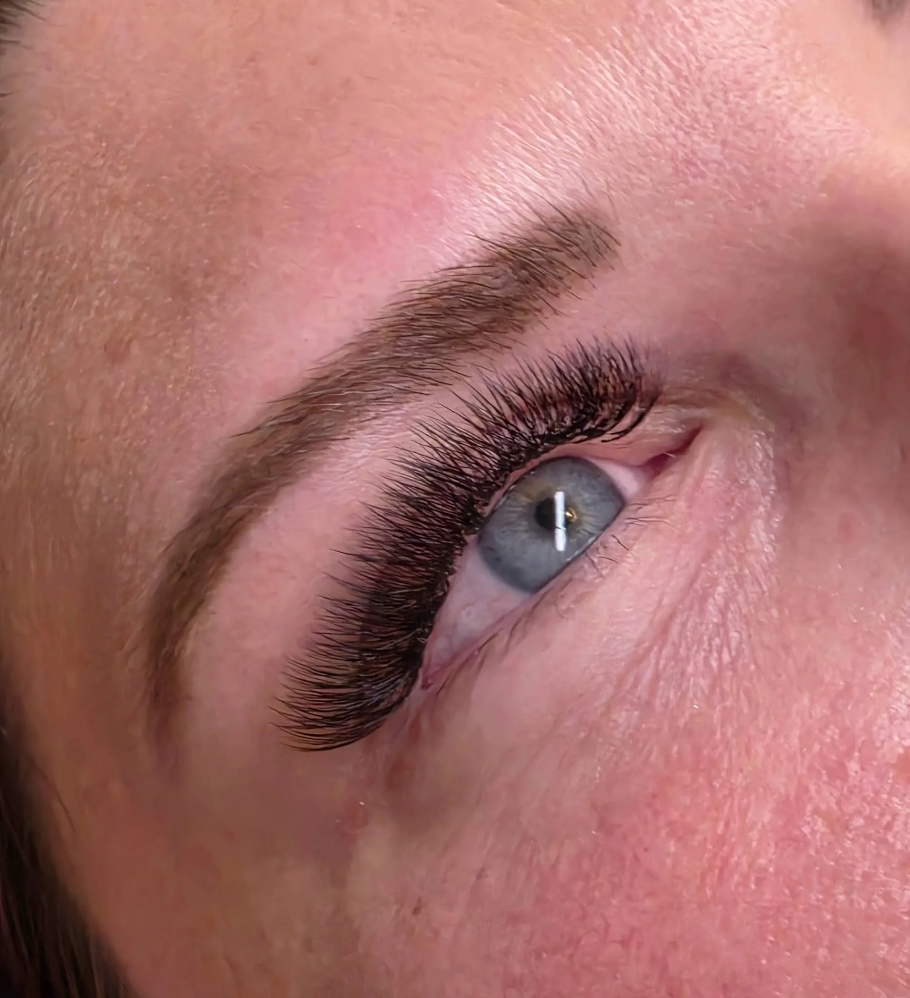 Mega volume lash fan — dramatic close-up, blue eyes